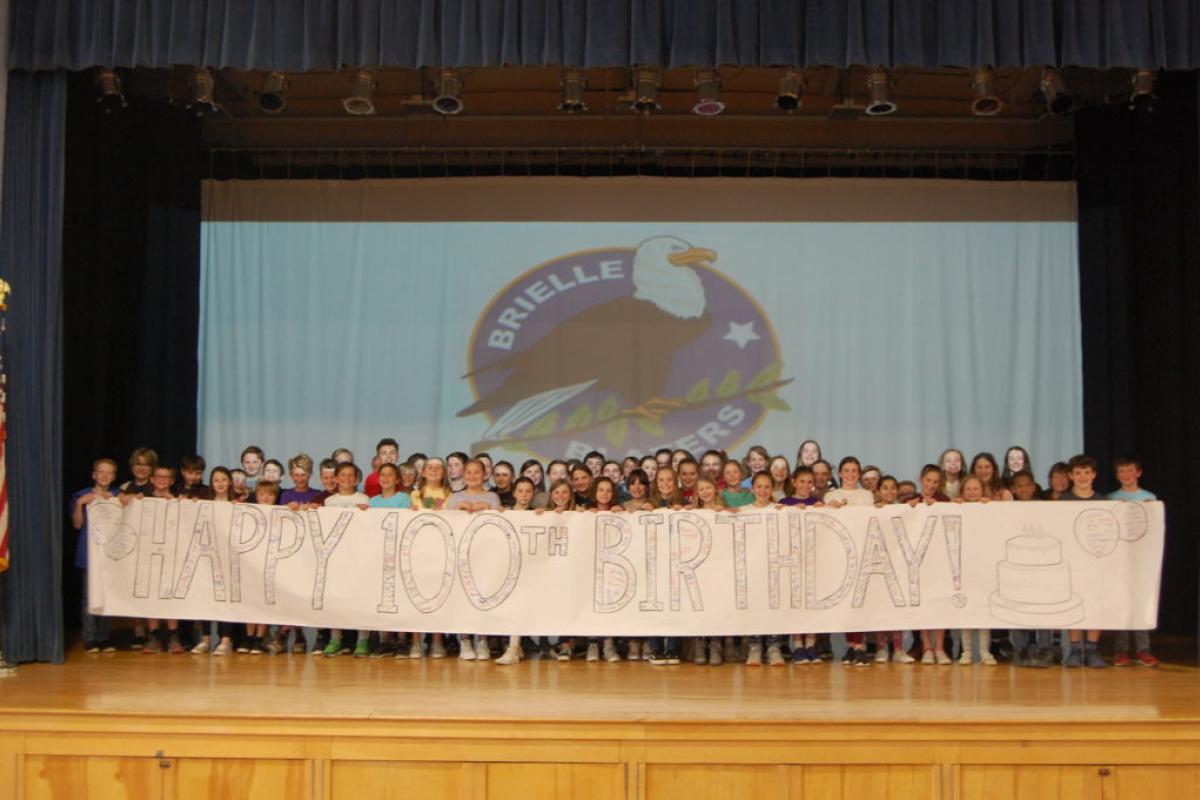 Children with "Happy 100th Birthday!" Banner