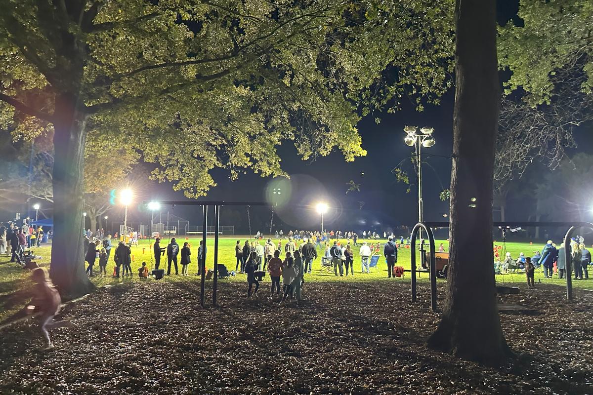 Children and coaches in the park at night